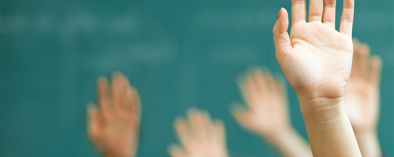 Several hands up against a green background